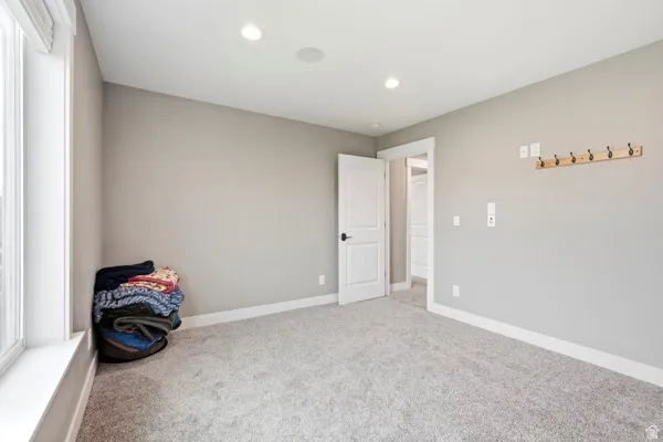 Recessed lighting, light gray wall paint, white trim, light gray carpet, and white paneled doors