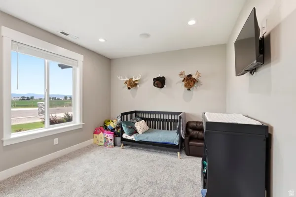 Recessed lighting, wall-mounted television, and a large window with white trim