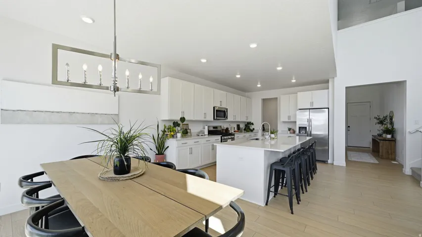 Modern kitchen featuring white cabinetry, stainless steel appliances, a large center island, and recessed lighting