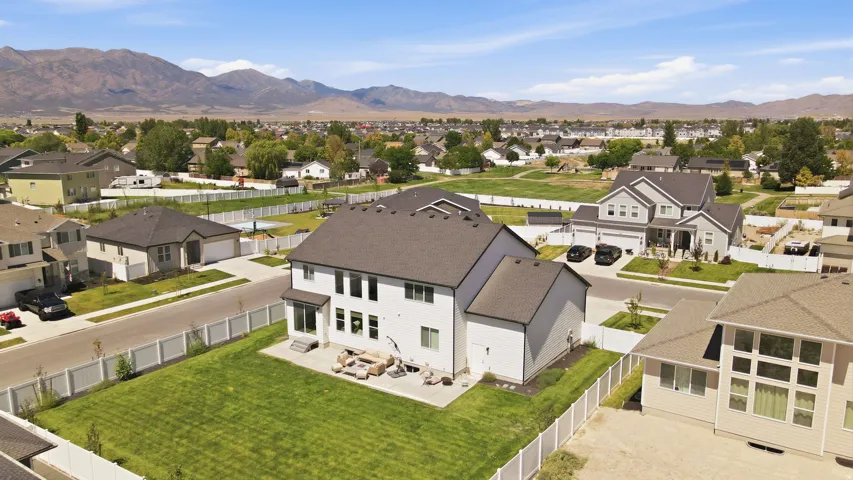 Expansive backyard featuring a manicured lawn, a paved patio area, and a privacy fence