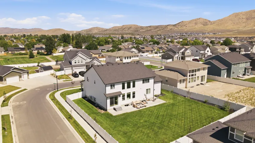 Expansive rear yard with a manicured lawn and concrete patio