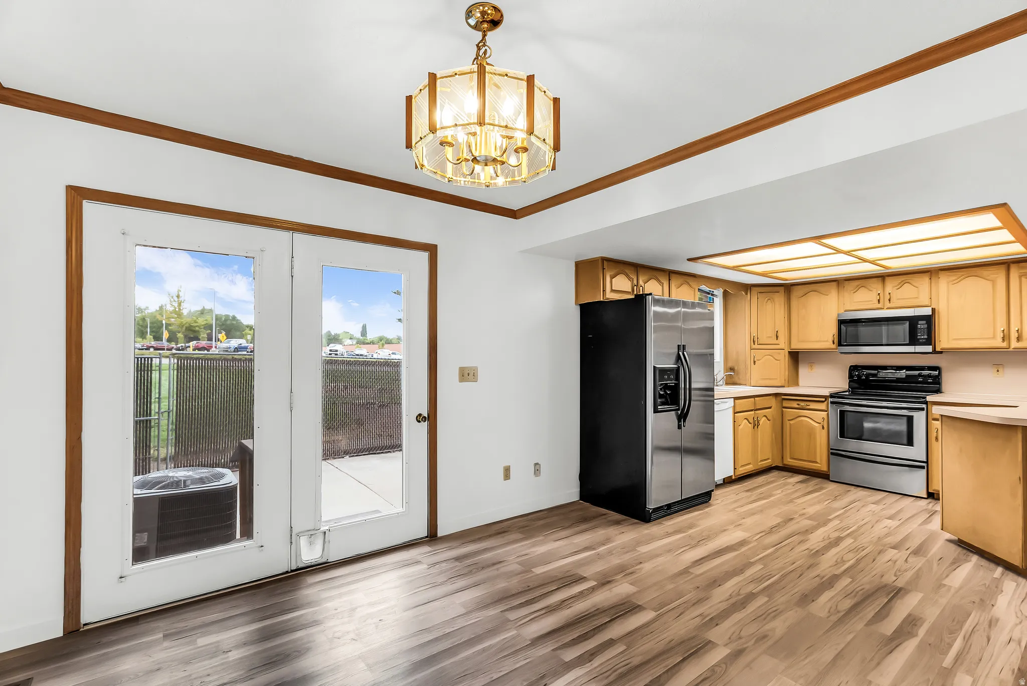 Wood-finish flooring throughout, with a classic chandelier and recessed ceiling lighting