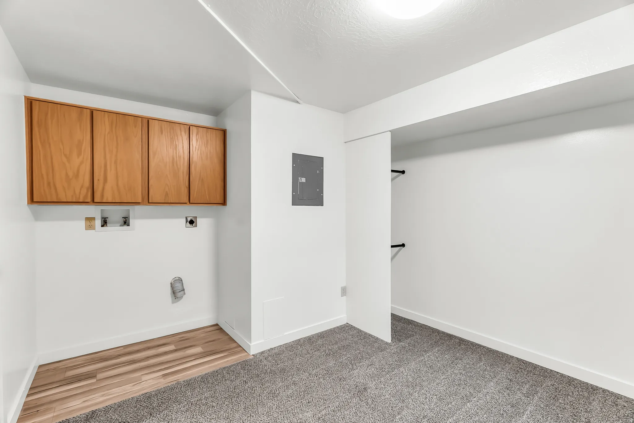 Laundry area with wood-finish cabinetry and utility hookups