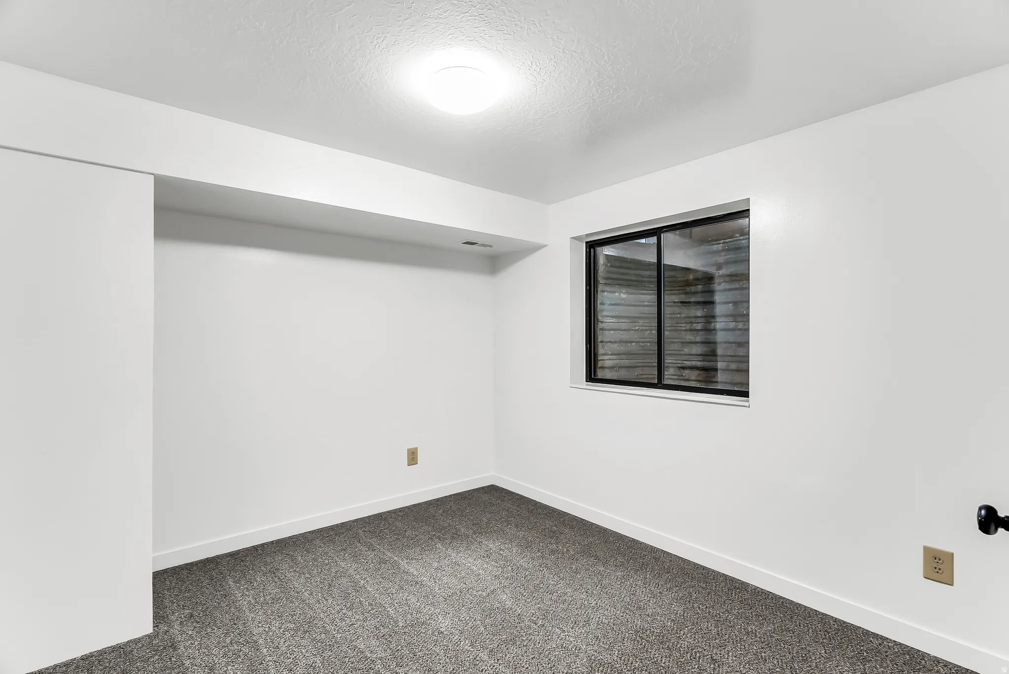 Recessed lighting, white walls, gray carpeting, horizontal sliding window, and white trim