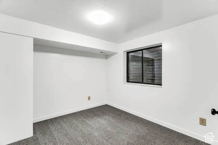 Recessed lighting, white walls, gray carpeting, horizontal sliding window, and white trim
