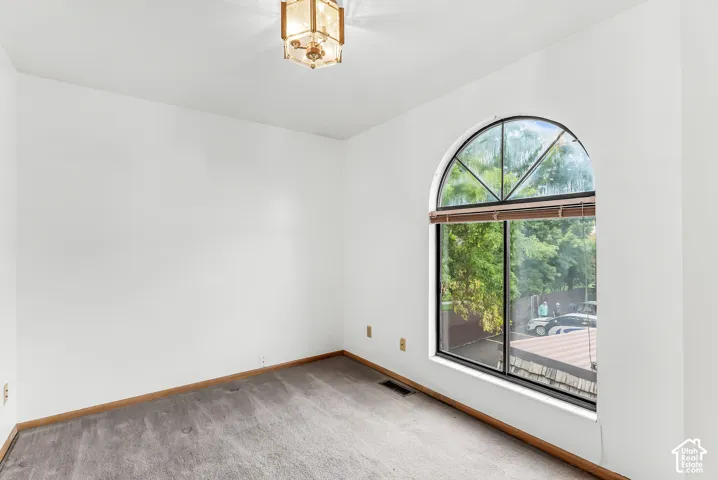 Arched window with wood blinds and a geometric light fixture