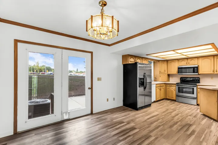 Wood-finish flooring throughout, with a classic chandelier and recessed ceiling lighting