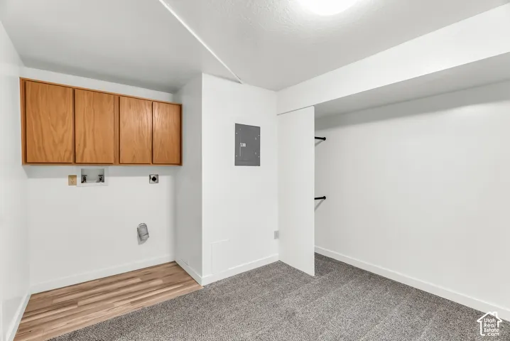 Laundry area with wood-finish cabinetry and utility hookups