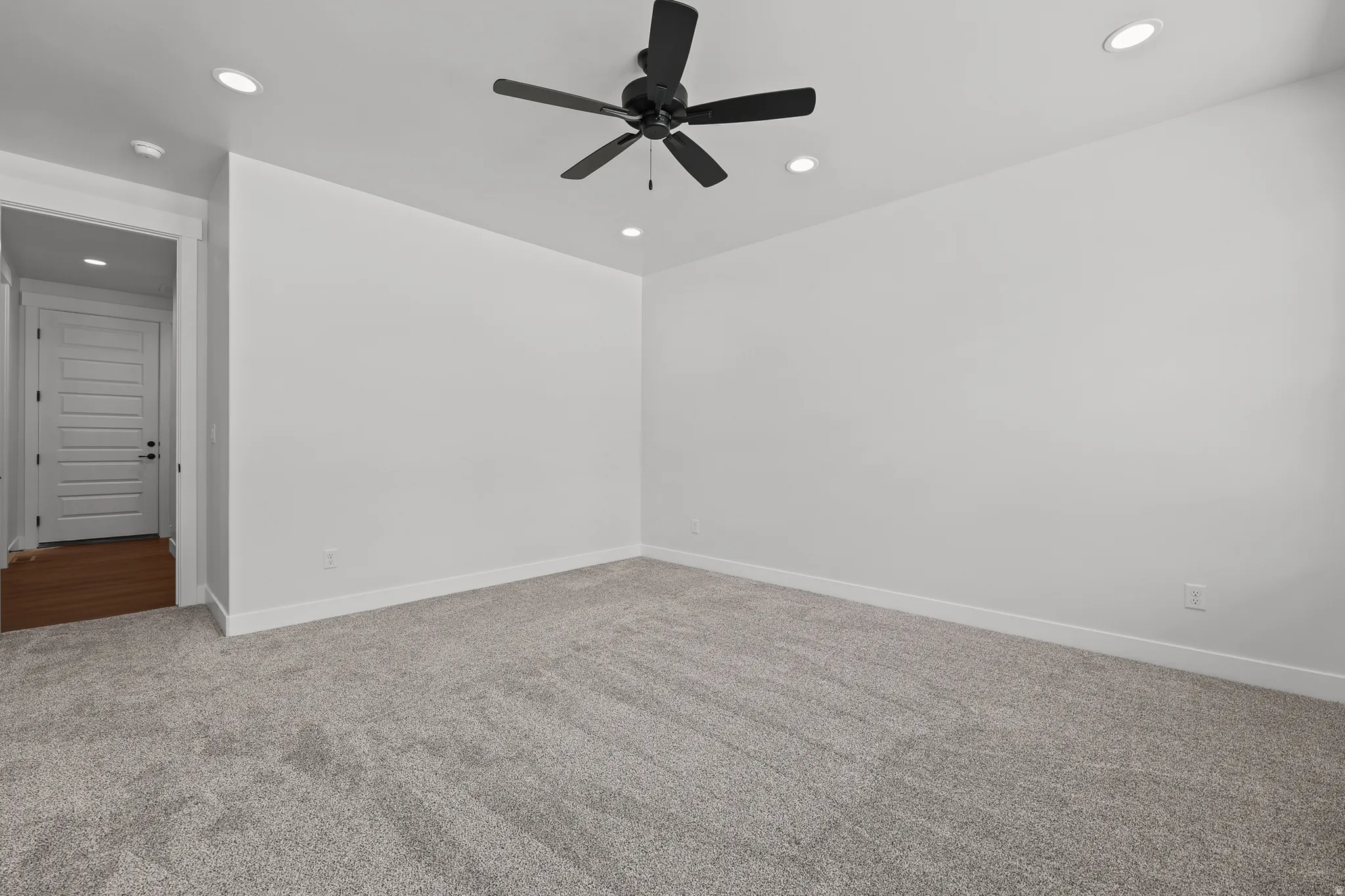 Recessed lighting, ceiling fan with matte black finish, light gray carpeting, white walls, and white trim