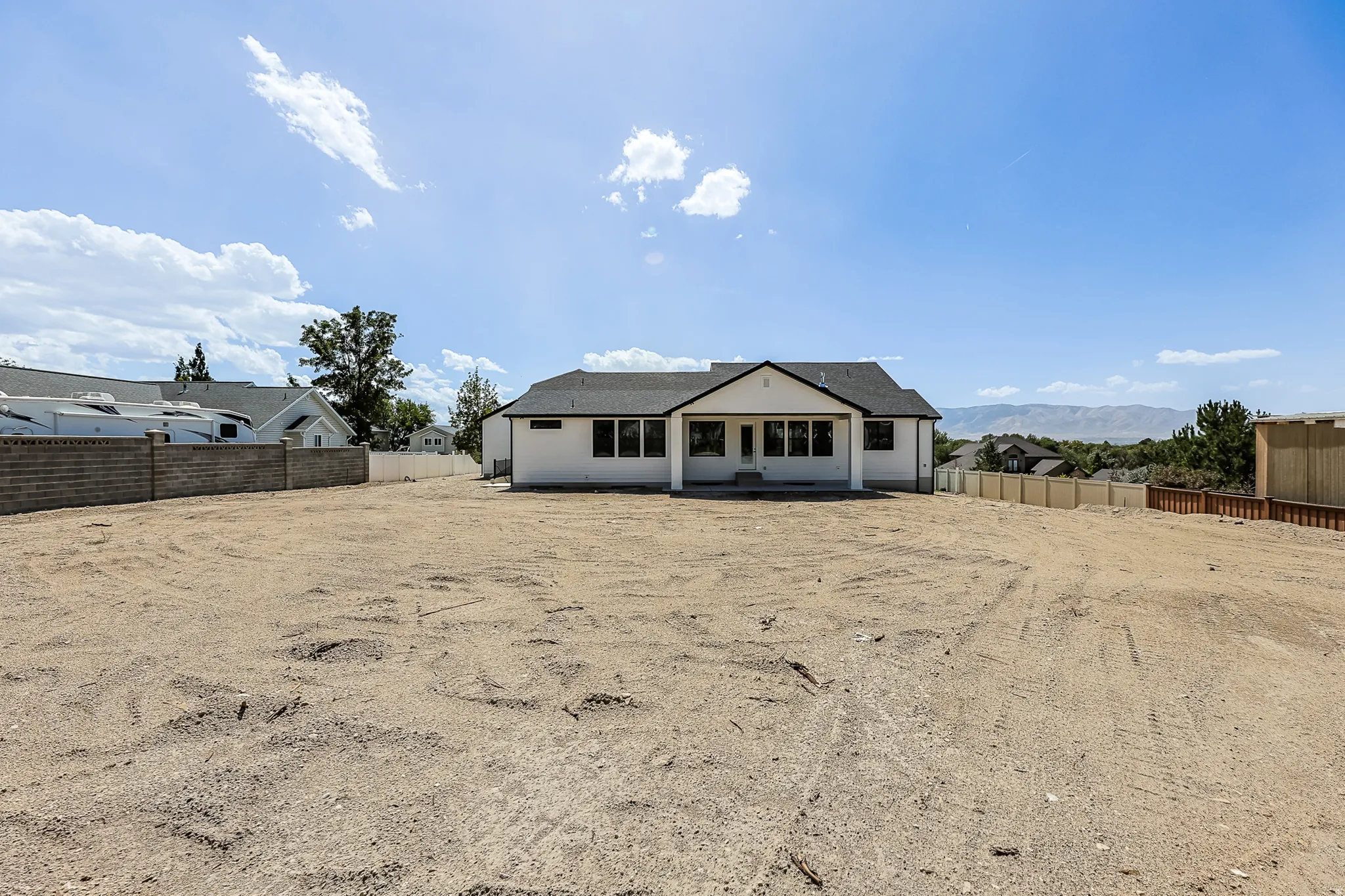 Spacious lot with a white stucco exterior and dark framed windows