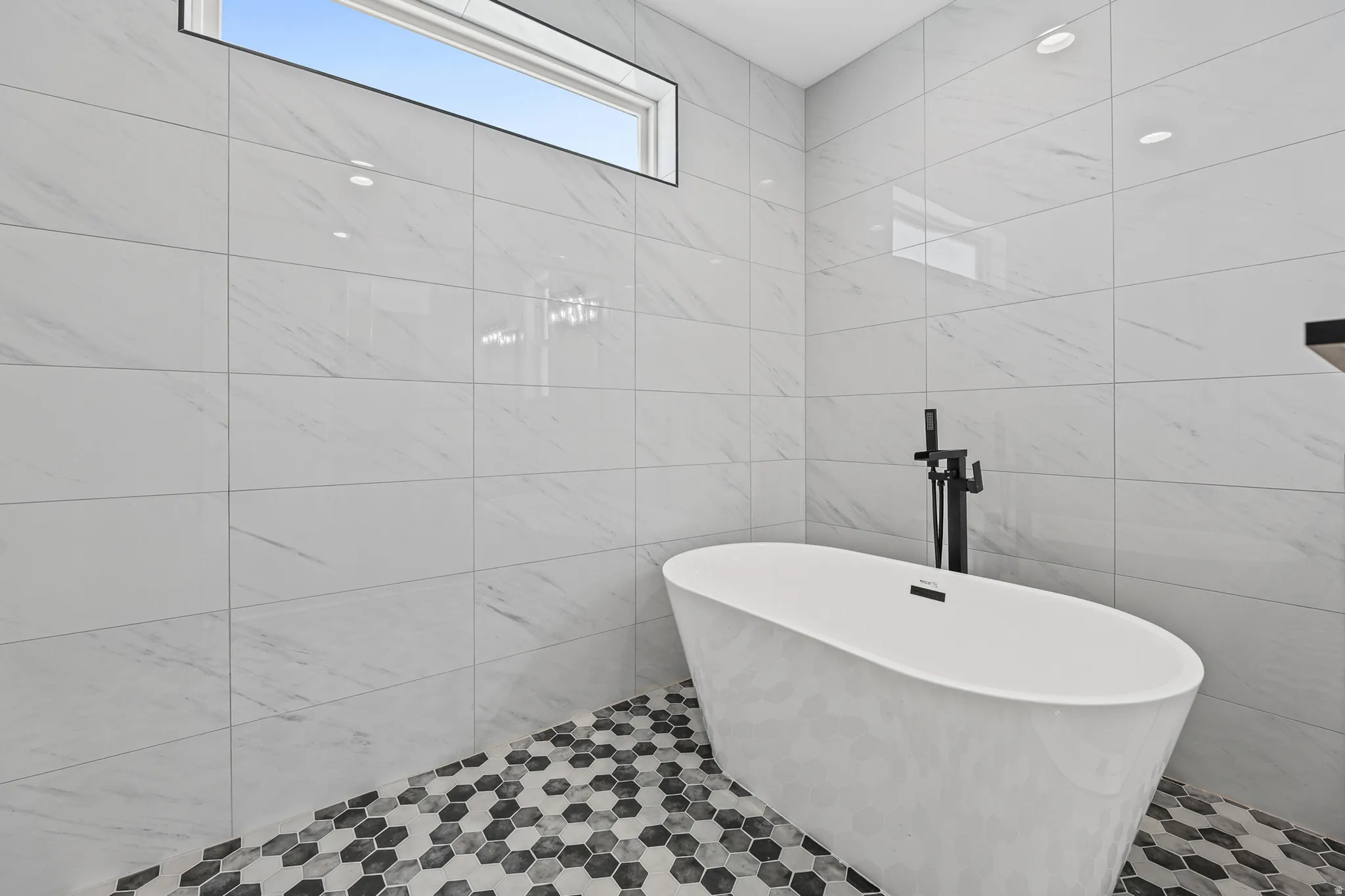 White freestanding soaking tub with matte black fixtures
