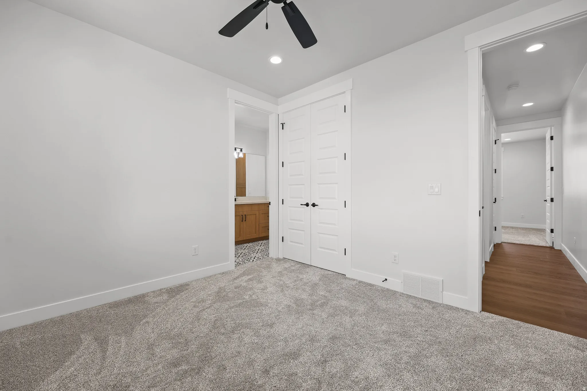 Plush carpeting, recessed lighting, and a ceiling fan