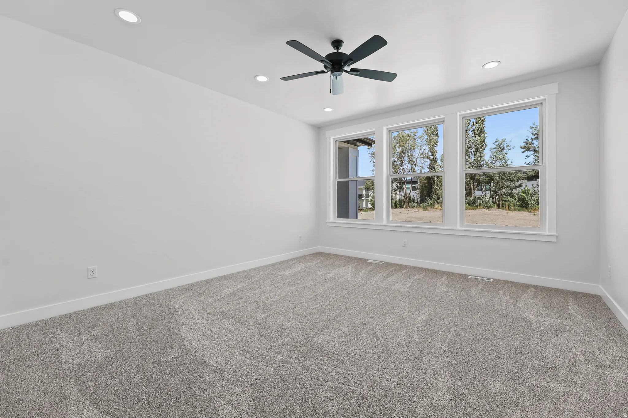 Recessed lighting, ceiling fan, and light gray carpeting