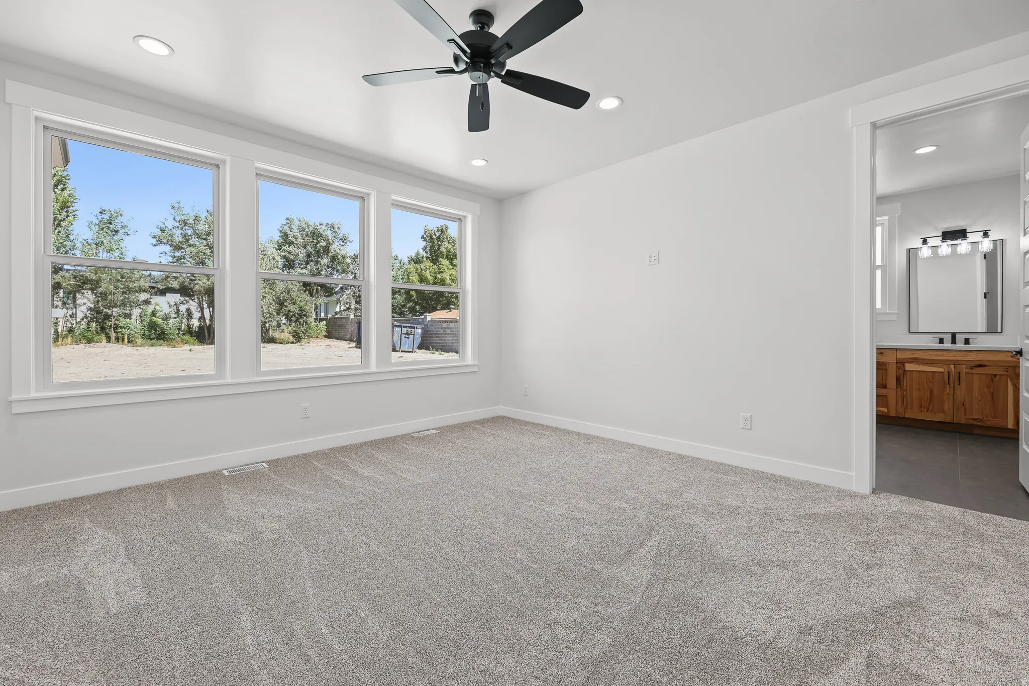Wall-to-wall carpeting and white walls with recessed lighting