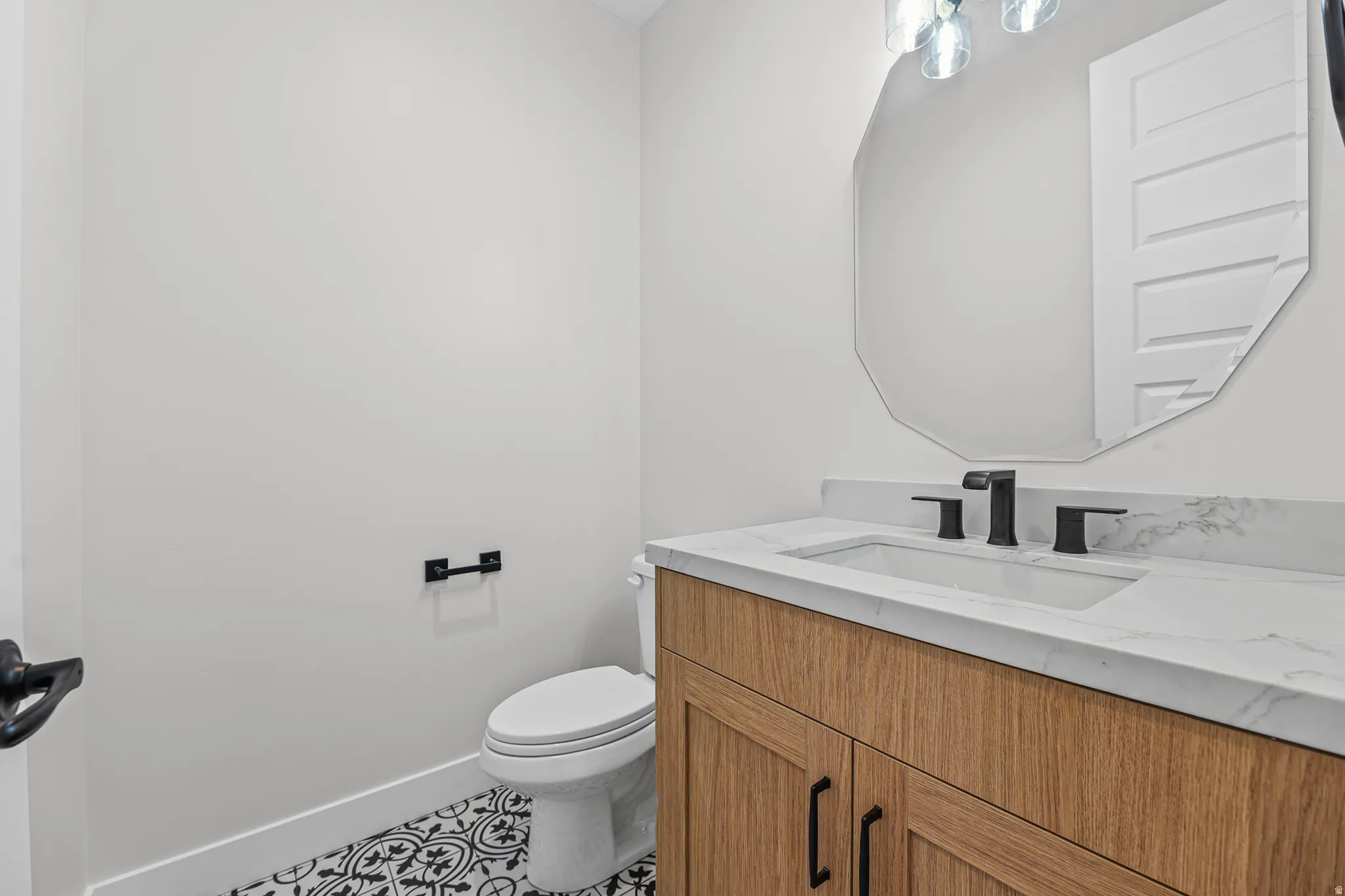 Light wood-finish vanity with a white countertop, undermount sink, and matte black faucet