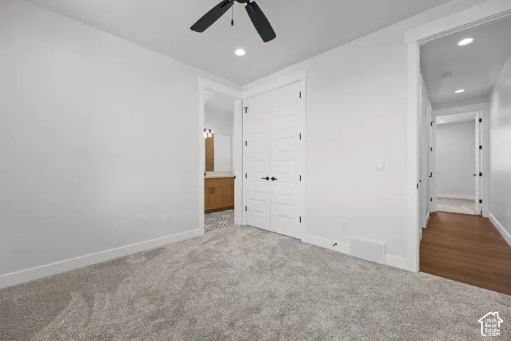 Plush carpeting, recessed lighting, and a ceiling fan