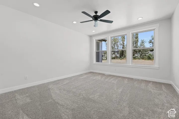 Recessed lighting, ceiling fan, and light gray carpeting