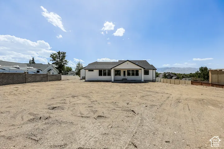 Spacious lot with a white stucco exterior and dark framed windows