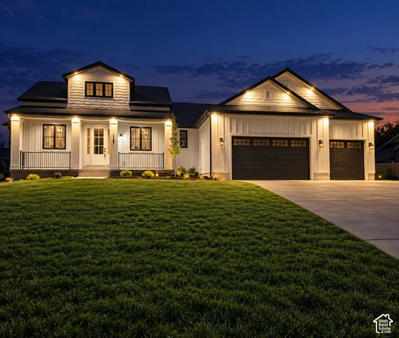 Modern farmhouse exterior with white vertical siding, black-framed windows, and a covered porch with black railings