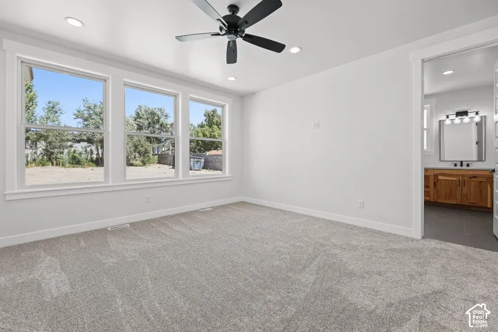 Wall-to-wall carpeting and white walls with recessed lighting