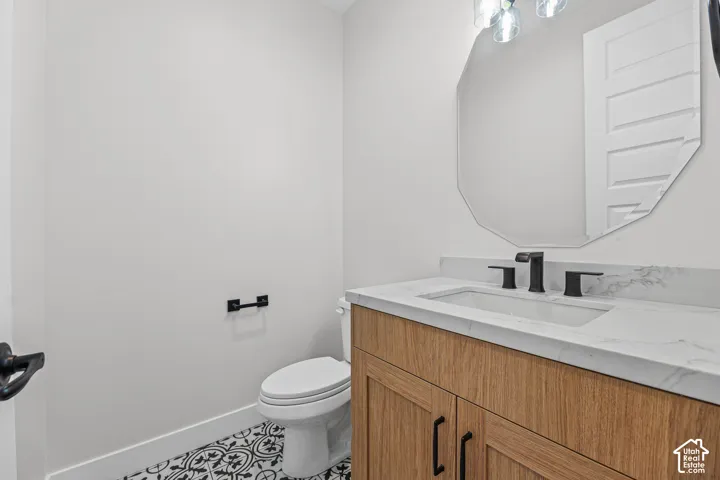 Light wood-finish vanity with a white countertop, undermount sink, and matte black faucet