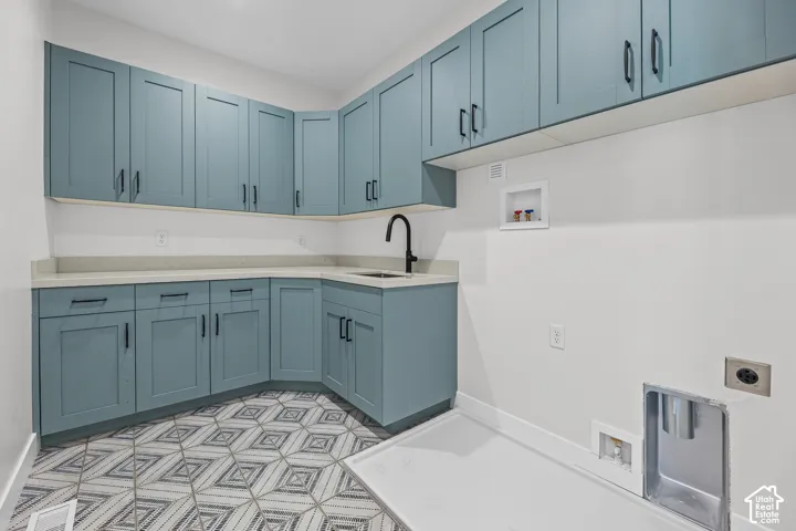 Extensive cabinetry with matte black hardware, light-toned countertops, and a built-in sink with a matte black faucet