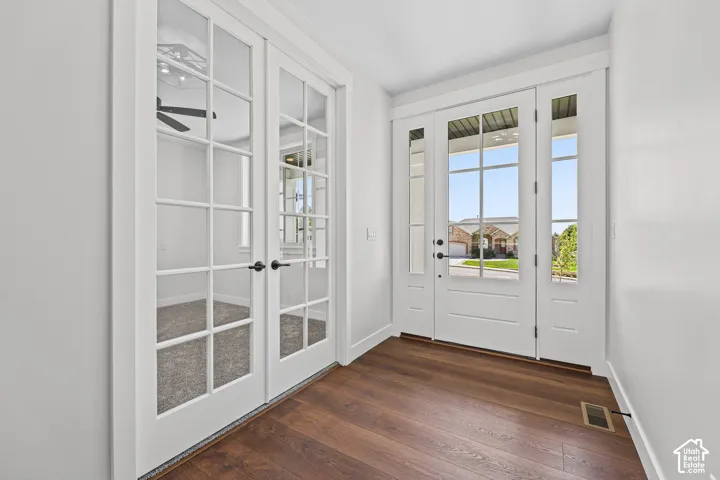 Entry featuring a white multi-pane front door, side windows, and wood-finish flooring
