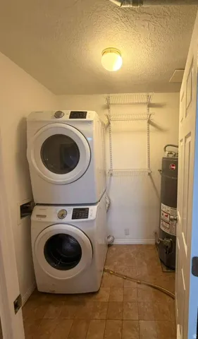 Laundry area featuring tiled flooring, built-in wire shelving, and a flush-mount ceiling light
