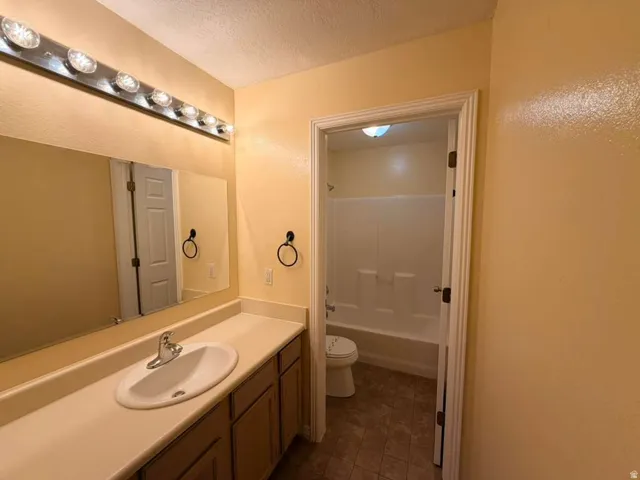 Vanity with integrated sink, chrome faucet, and expansive mirror