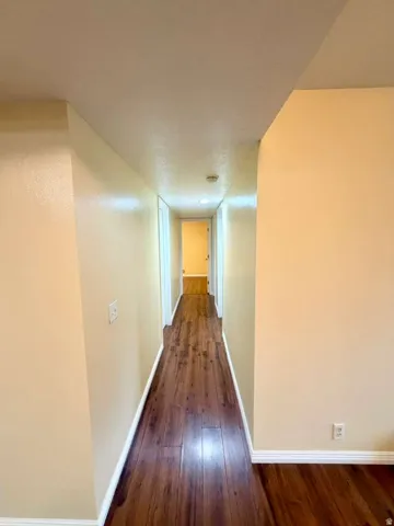 Wood-finish flooring throughout the hallway, complemented by neutral-toned walls