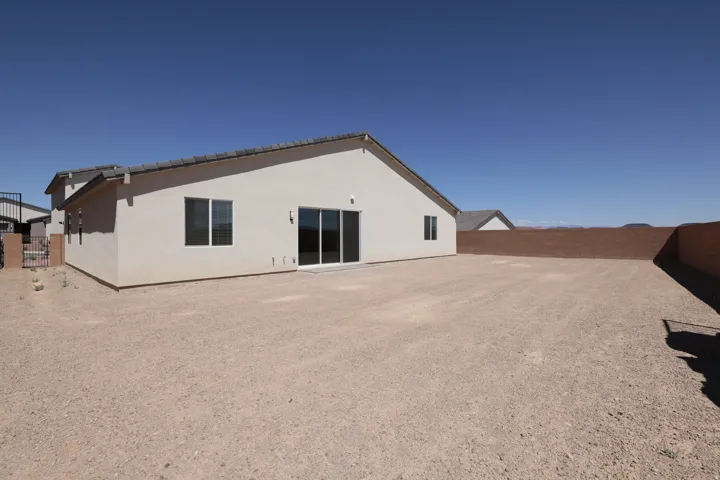 Stucco exterior featuring multiple windows and a sliding glass door