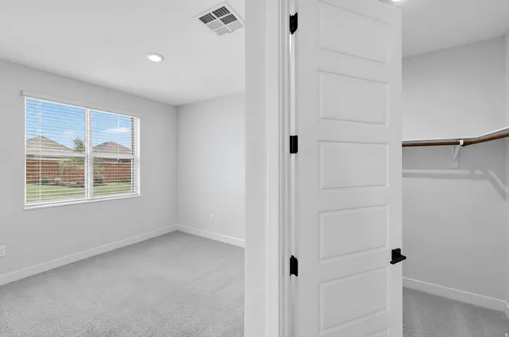 Recessed ceiling lighting, window with blinds, light gray carpeting, and a built-in closet rod