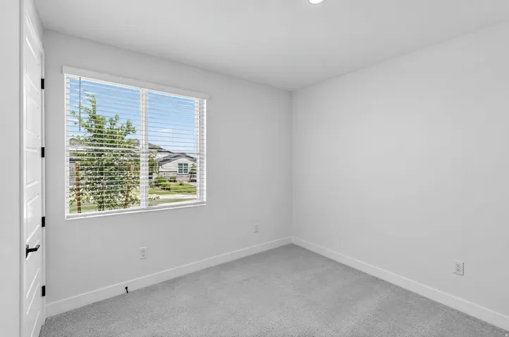 Recessed ceiling lighting, white walls, and light gray carpeting