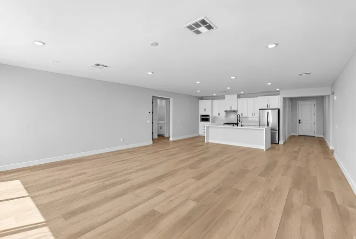 Open-concept living area featuring wood-finish flooring and recessed lighting