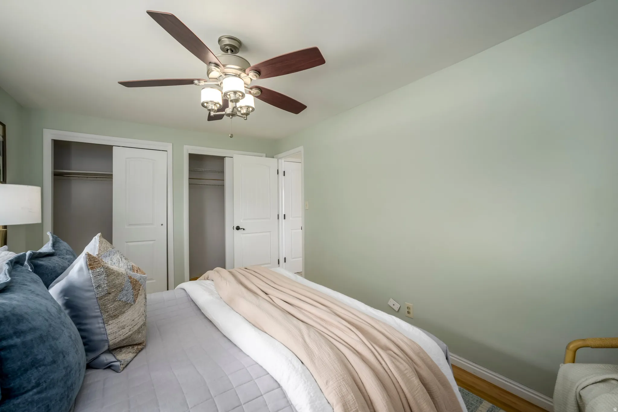 Recessed ceiling fan with light fixture, dual sliding closet doors, and wood-finish flooring