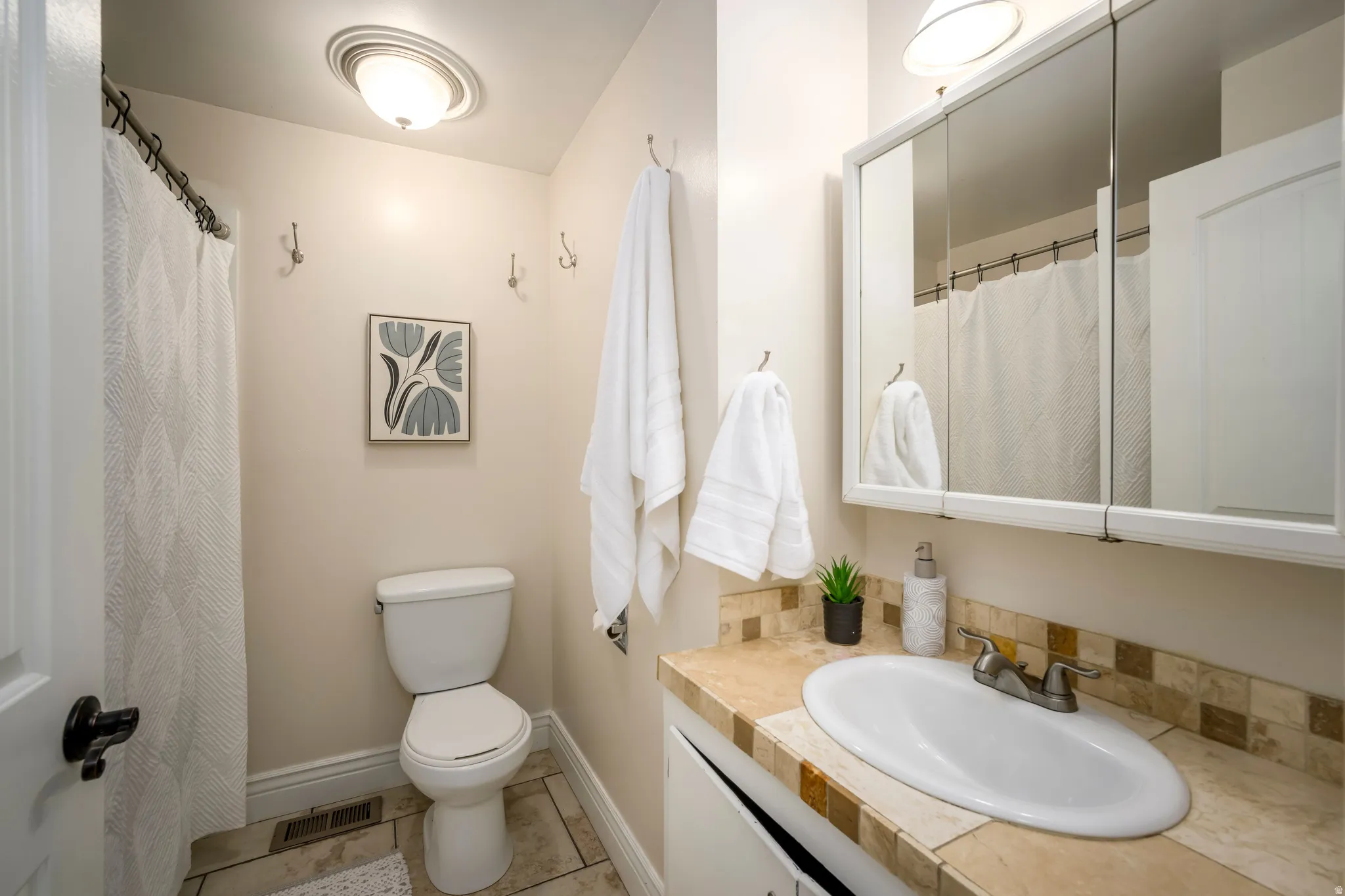 Vanity with an integrated white sink, tiled countertop, and matching tiled backsplash
