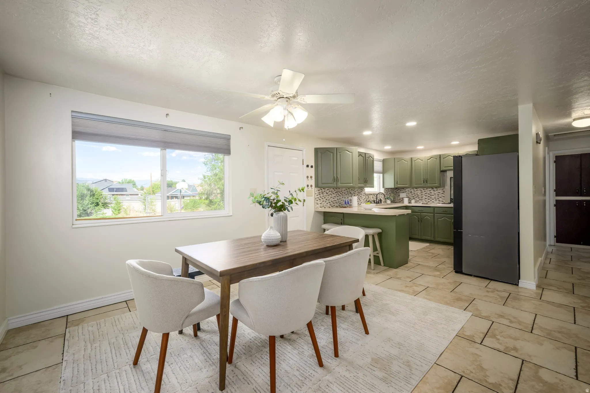 Kitchen featuring green cabinetry, mosaic tile backsplash, and recessed lighting