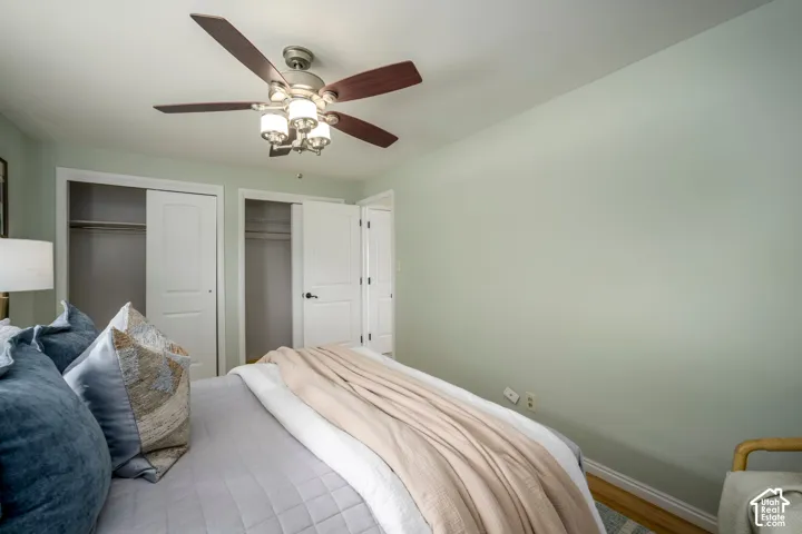 Recessed ceiling fan with light fixture, dual sliding closet doors, and wood-finish flooring