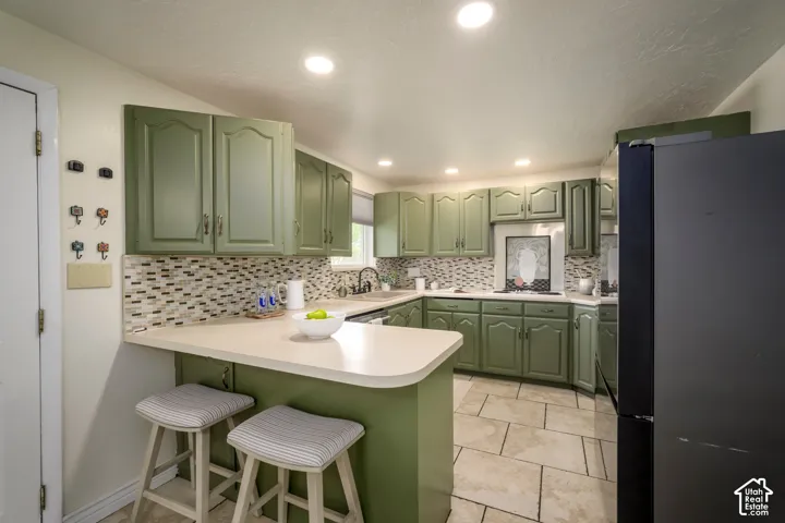 Kitchen featuring ample cabinetry, mosaic tile backsplash, solid surface countertops, and tile flooring