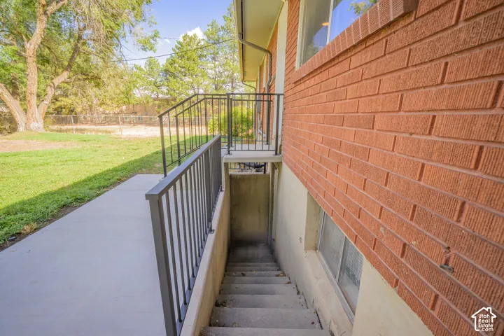 Red brick exterior with a concrete walkway and dark metal railings