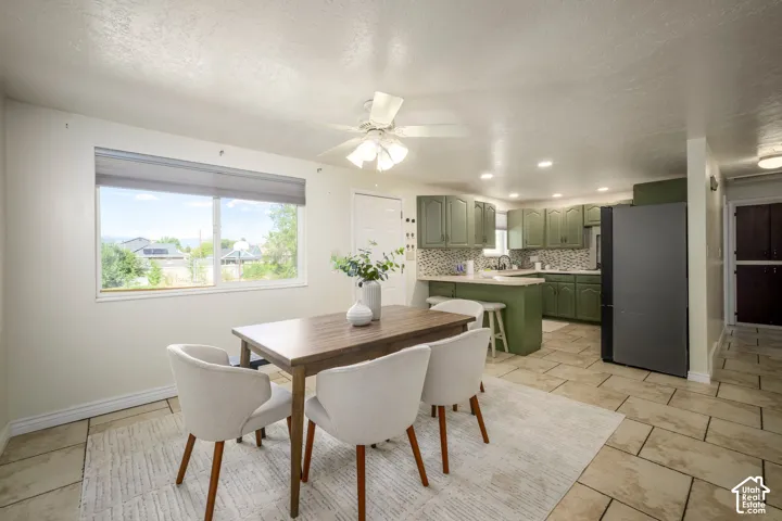 Kitchen featuring green cabinetry, mosaic tile backsplash, and recessed lighting