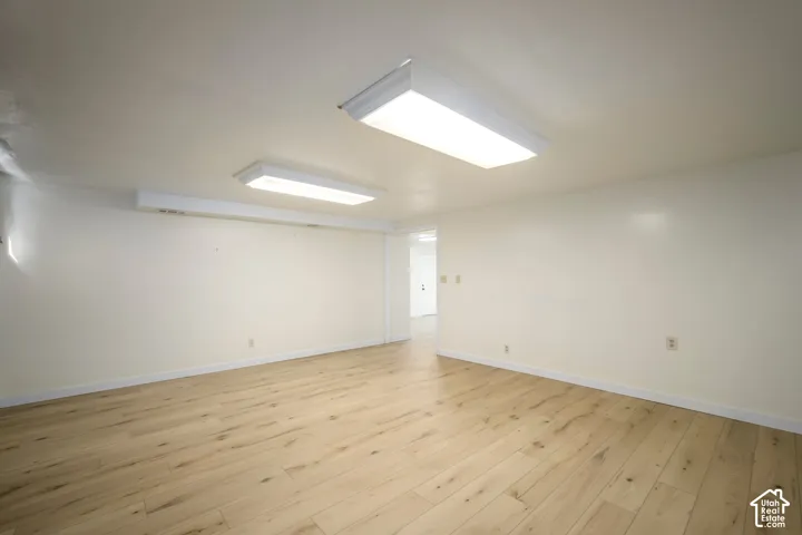 Light wood-finish flooring, white walls, and two ceiling-mounted rectangular light fixtures