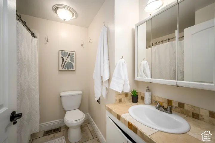 Vanity with an integrated white sink, tiled countertop, and matching tiled backsplash