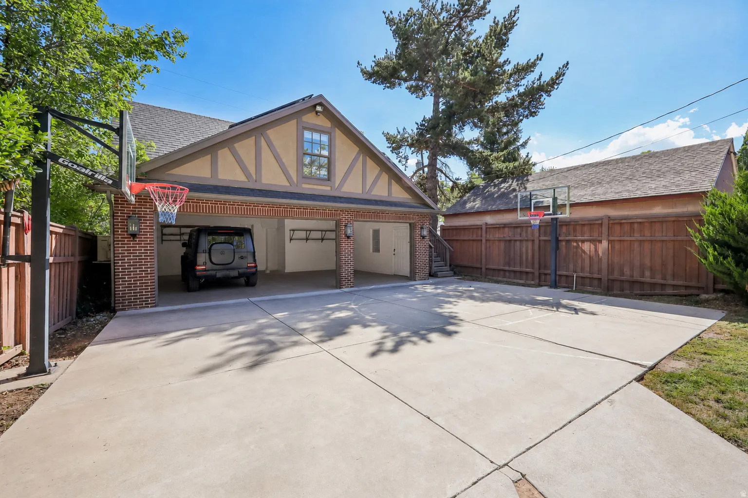Attached two-car garage featuring brick columns and exposed timber framing