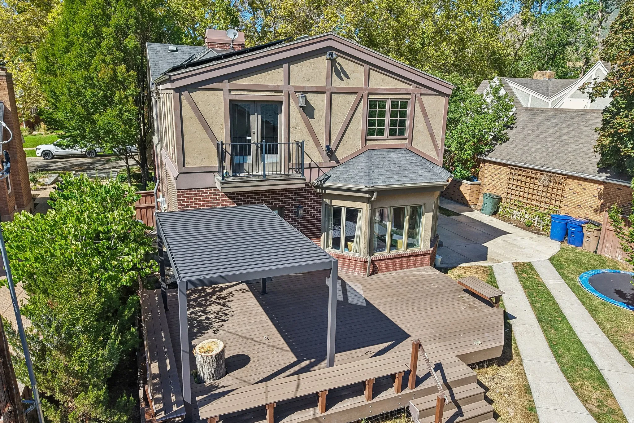Multi-level wood-finish deck with built-in bench seating and a shaded pergola
