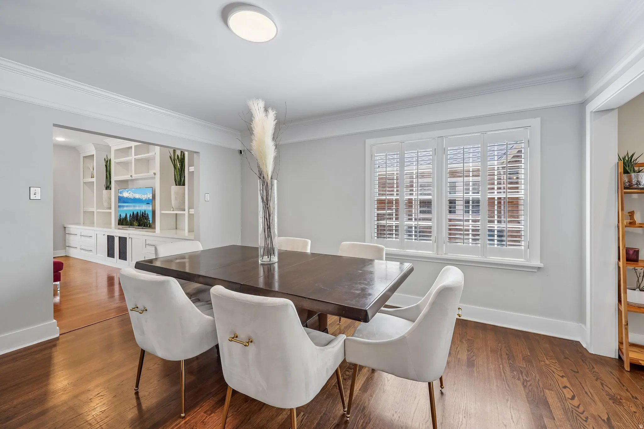 Hardwood flooring, recessed lighting, built-in shelving, crown molding, and window shutters