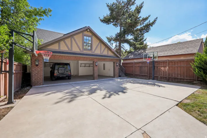 Attached two-car garage featuring brick columns and exposed timber framing