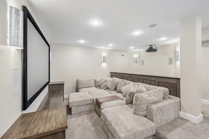 Built-in media console, recessed lighting, wall-mounted sconces, projector, and screen