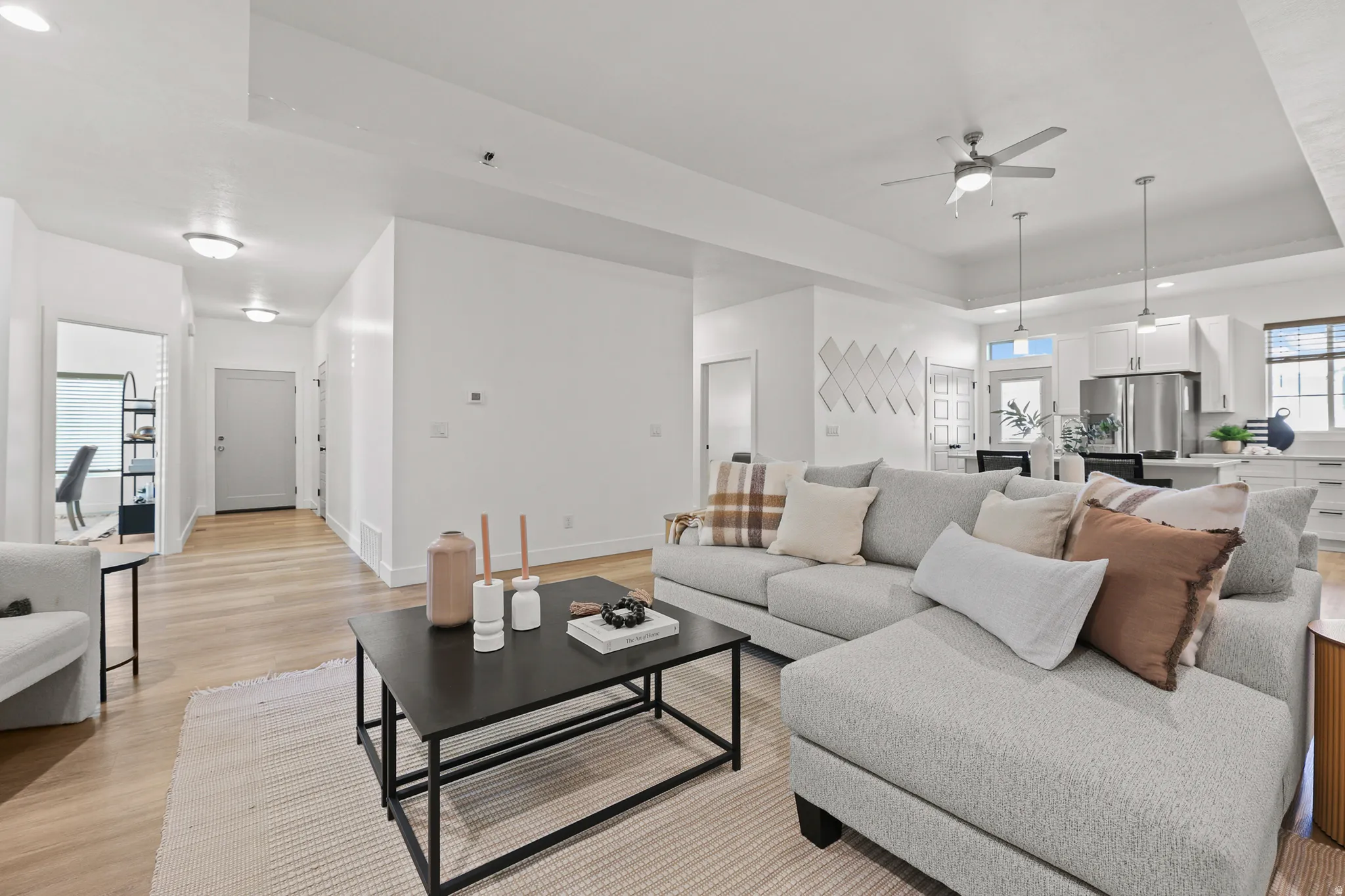 Open-concept living area with wood-finish flooring, recessed lighting, and a ceiling fan