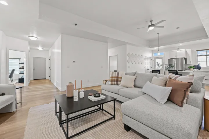 Open-concept living area with wood-finish flooring, recessed lighting, and a ceiling fan
